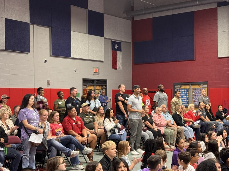 veterans standing to be honored in the crowd