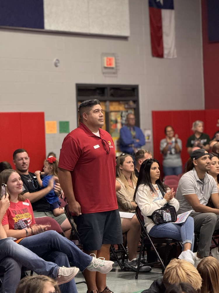A veteran standing up to be honored in the crowd