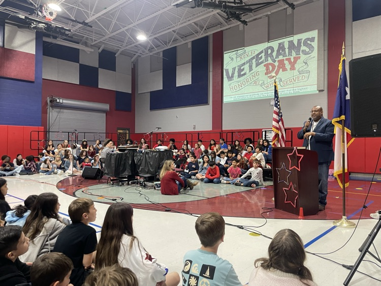 Mr. Butler, speaking with the choir sitting next to him to the crowd
