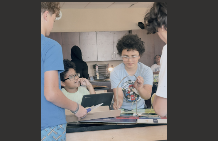 students building a cardboard roller coaster