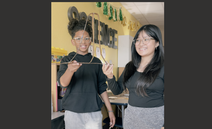 students holding up a piece of their project