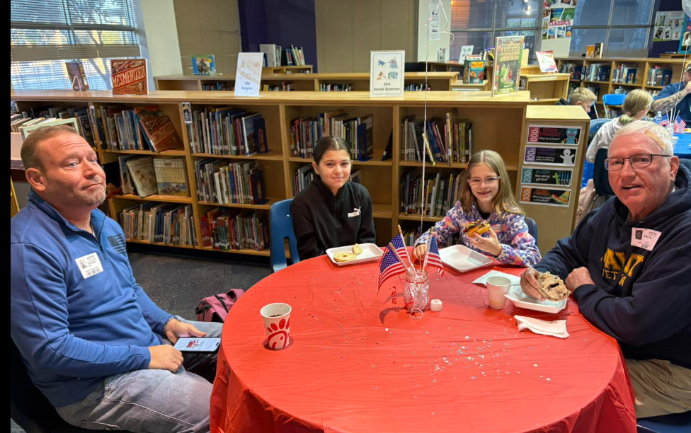 veterans and students eating donuts