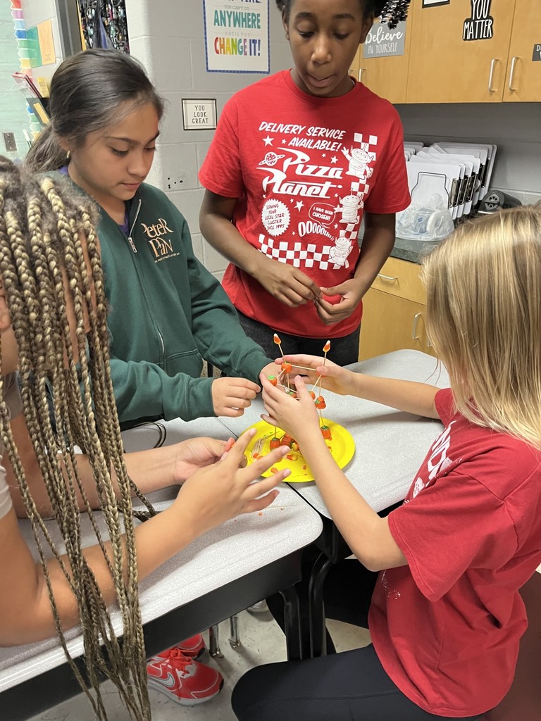4 girls using the materials to build a tower