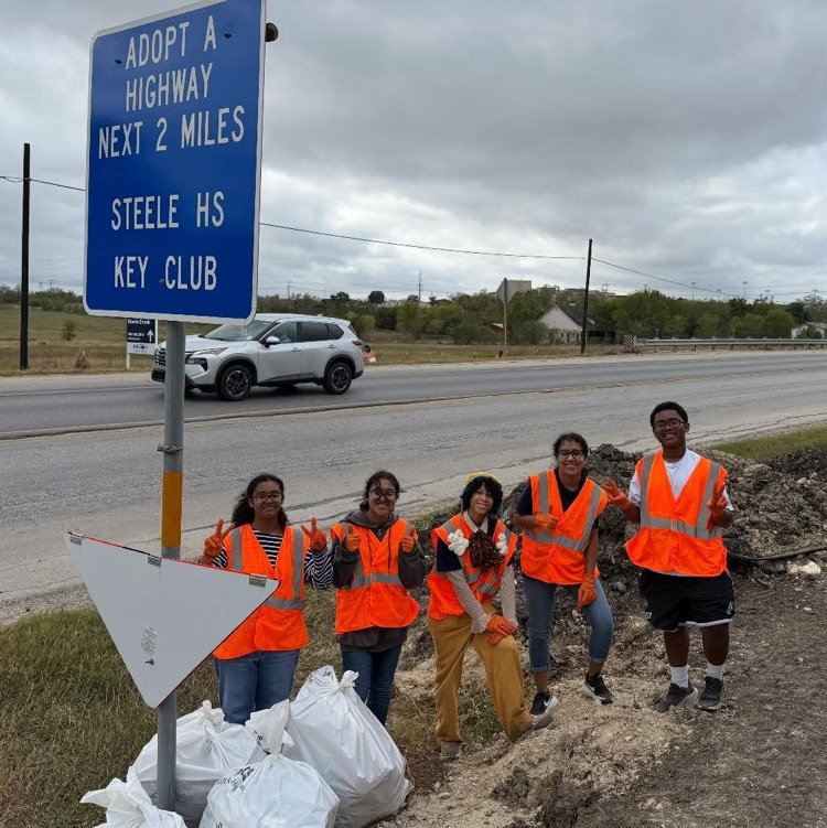 students clean trash from the road side