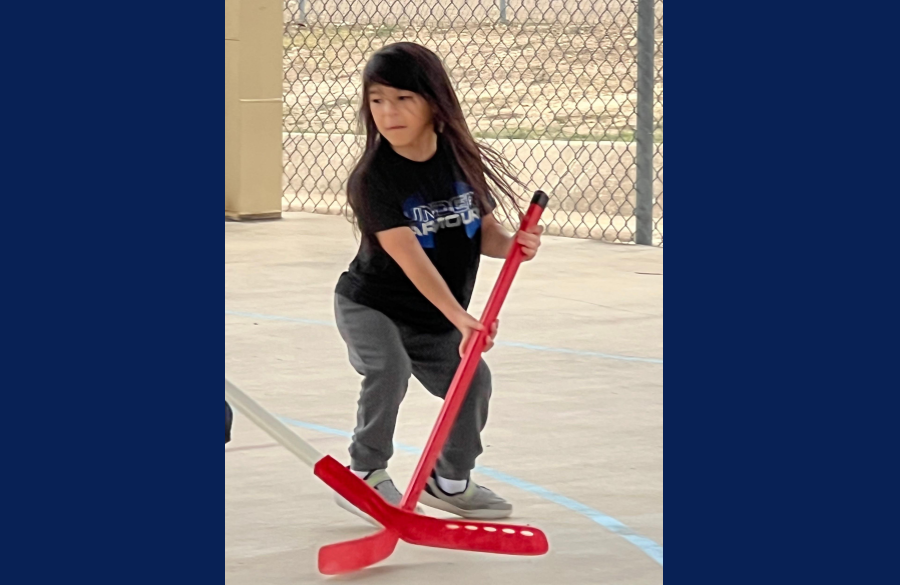 student playing hockey in PE