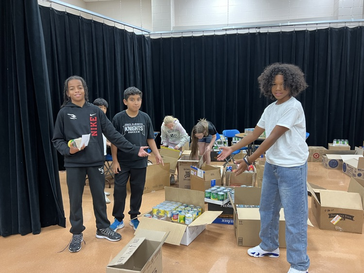 boys showing off the boxes of canned goods