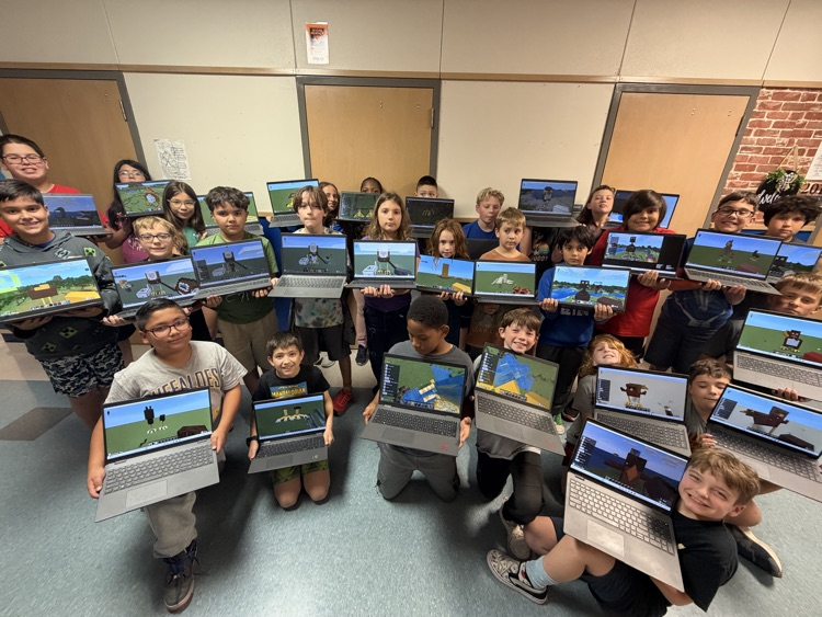 Minecraft Club members pose with their laptops