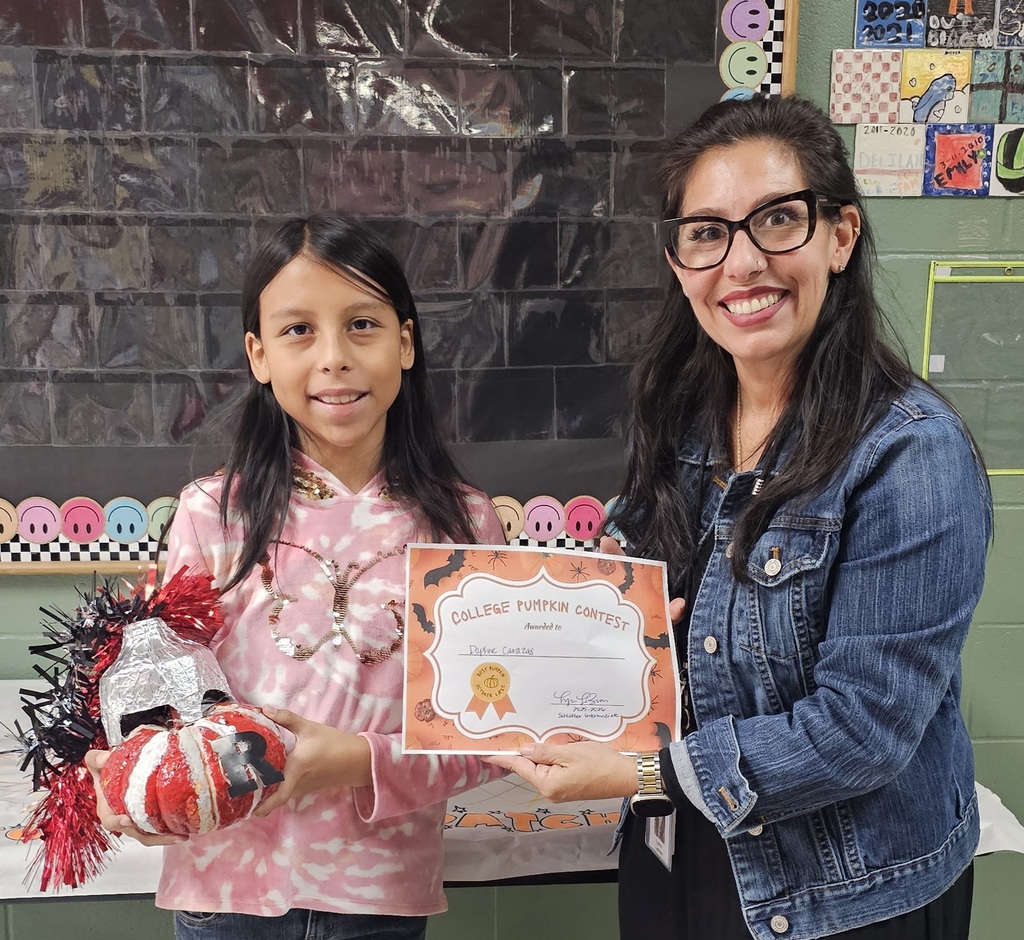 student with a raider decorated pum pkin next to labron 