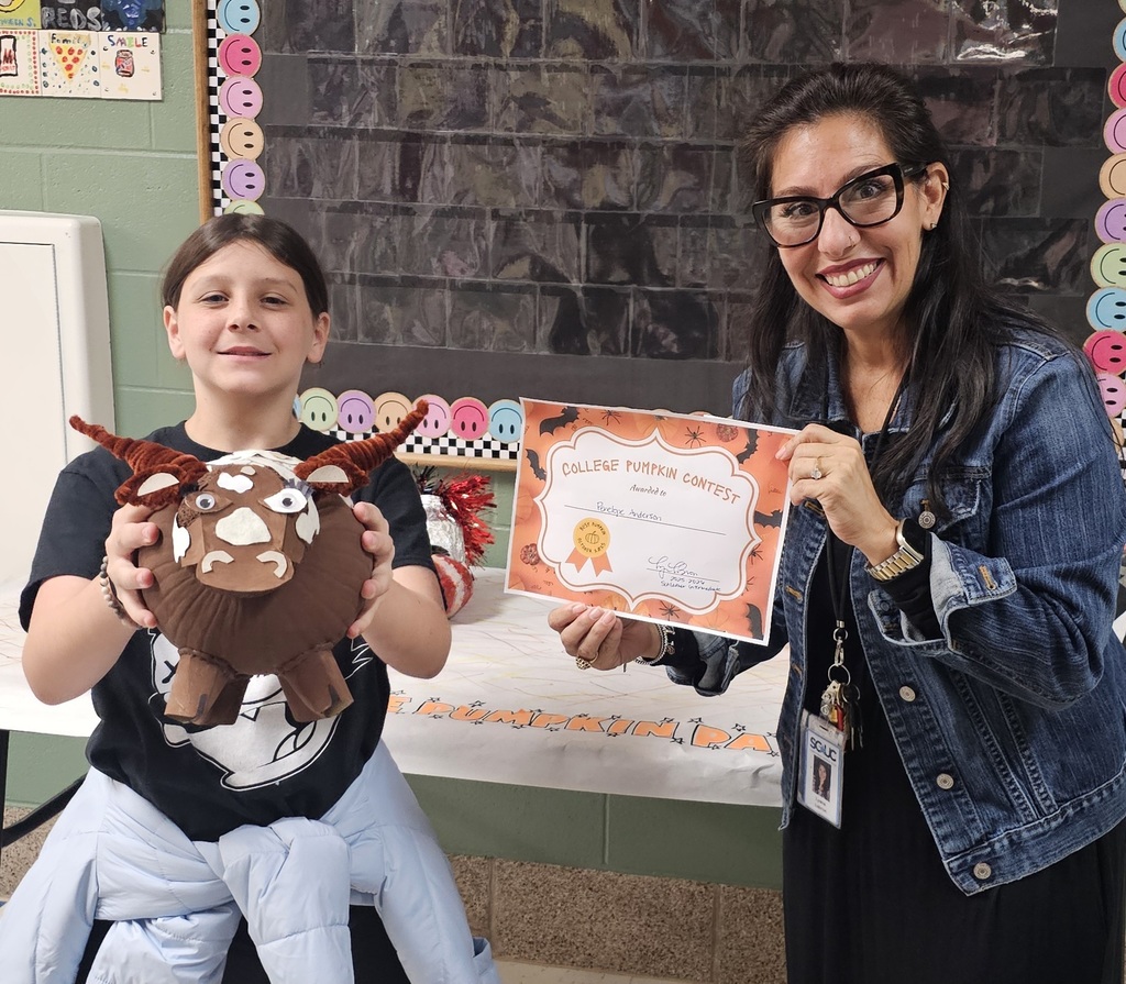 Pumpkin contest winner with a longhorn pumpkin next to labron