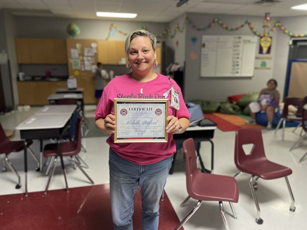 mrs stafford with her award in her classroom