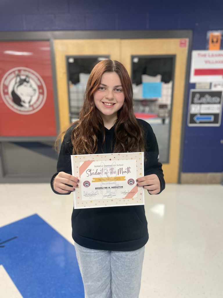 5th grade student with her award in front of the Choir room