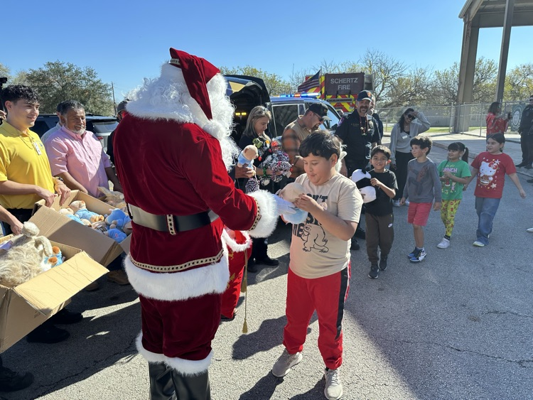 Santa surprising Schertz Elementary students to with their own new stuffed animal !!!!