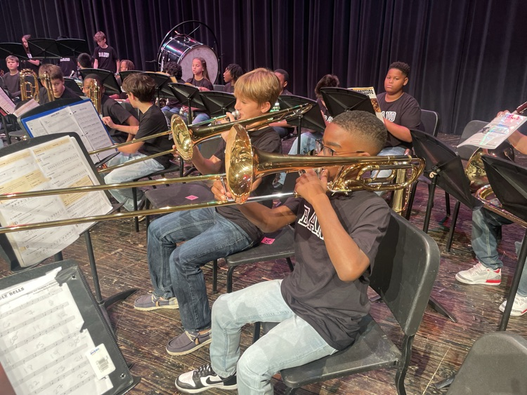 Students playing the trombone on the stage