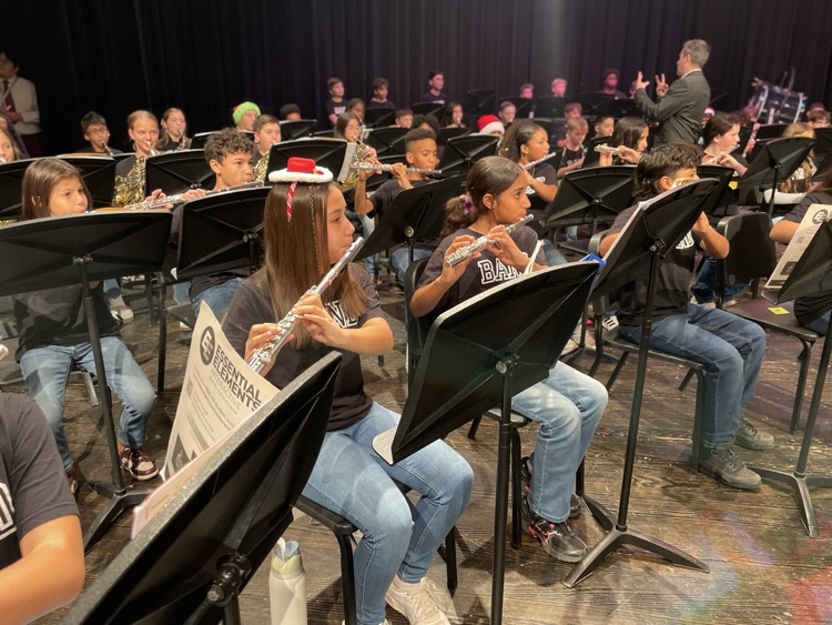student is playing the flute on the stage