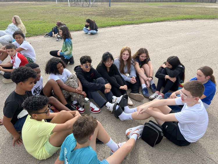 students sitting in circle outside