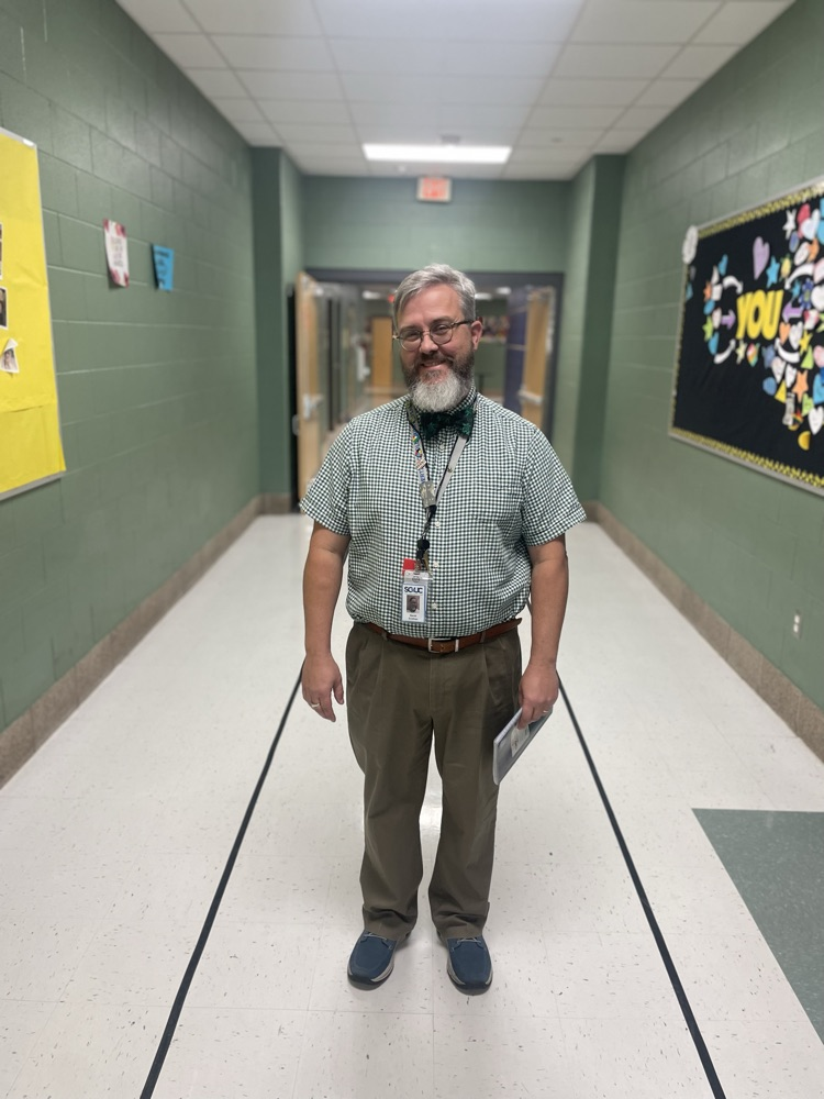 mr. Sneeden with his award in the hallway
