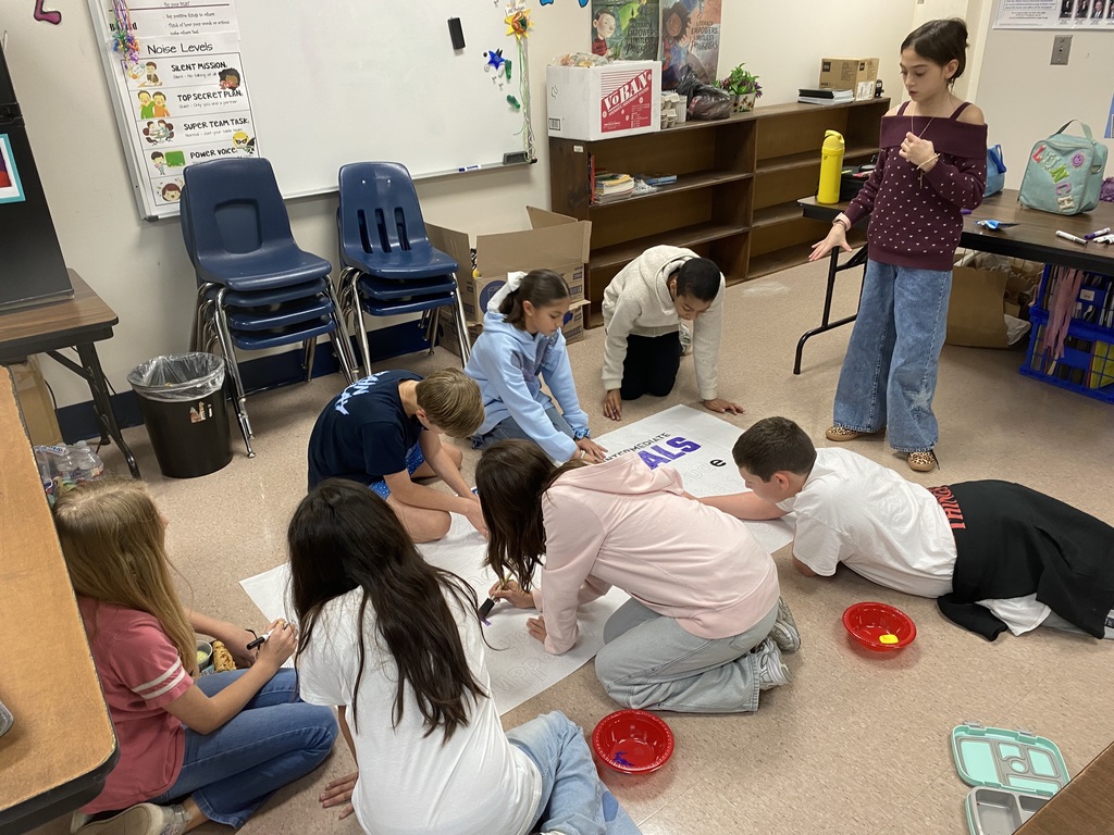 more students helping paint poster
