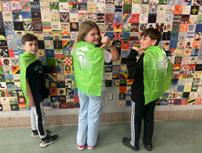 3 students posing with their capes on