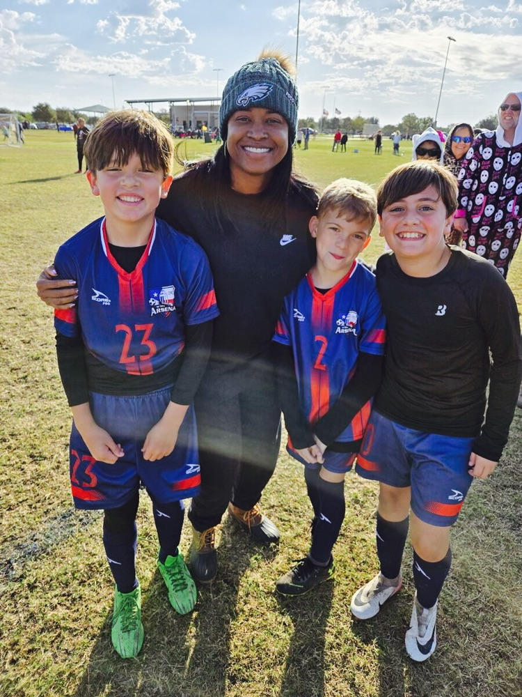 Mrs. Jackson with students on the soccer field 
