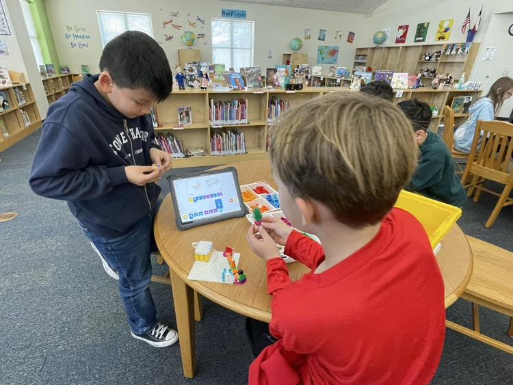 students building and coding Lego in the library