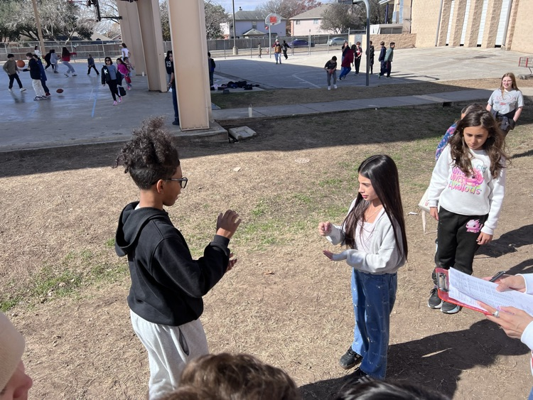 two students battle it out playing rock paper scissors 