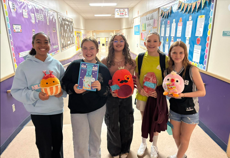 Girls posing with their raffle winnings from the school store