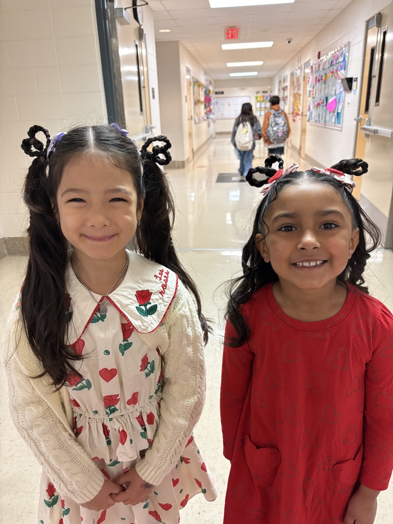 two students smiling with the same hairstyle at school
