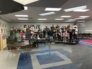 students singing in the choir room on the risers