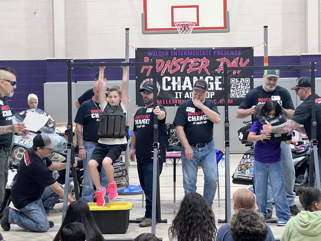 5th grader hanging from a bar with a weighted vest.