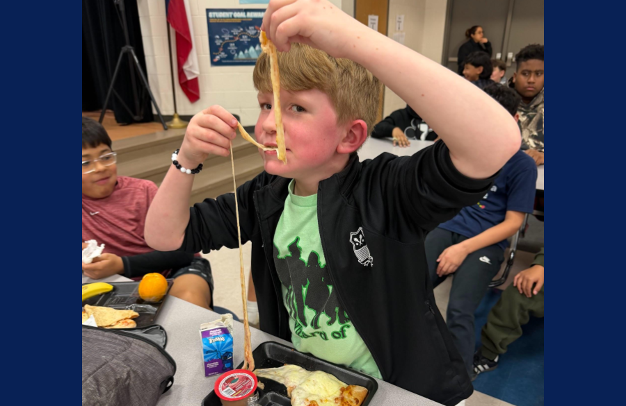 picture of student eating pizza with an amazing cheese pull