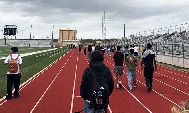 high school students walk on a track
