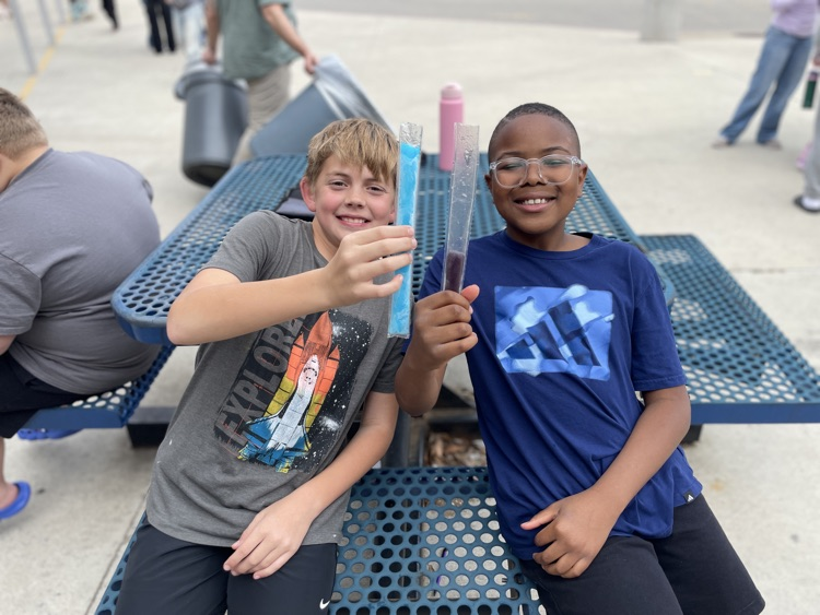 two boys having a popsicle outside