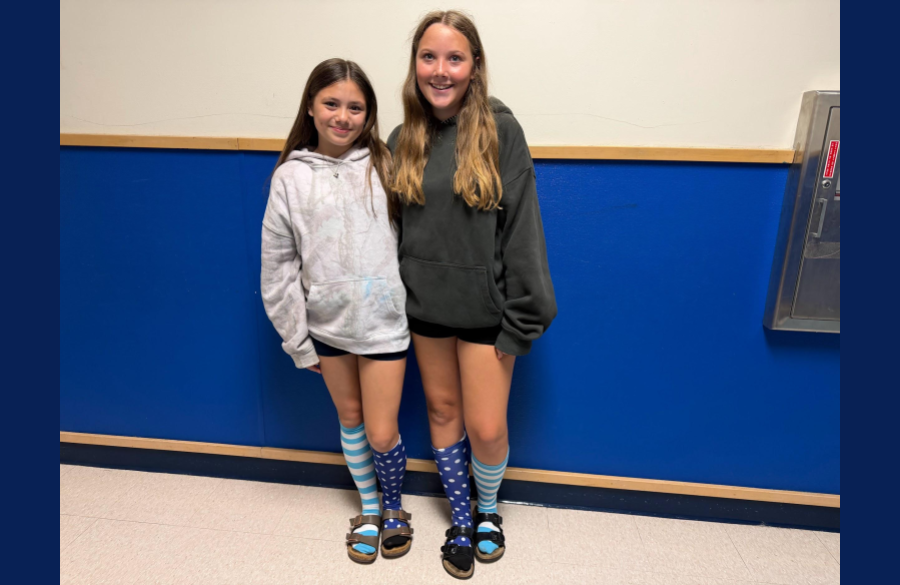 A picture of two students posing while wearing crazy socks for World Down Syndrome Awareness on March 21