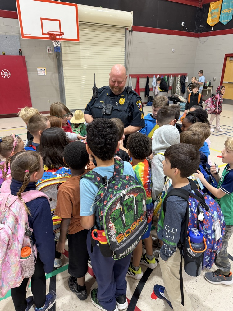 police officer handing out stickers to students