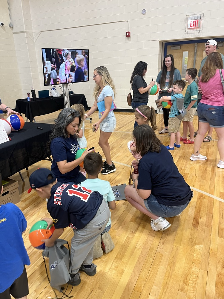 adult teachers working with little children using beach balls