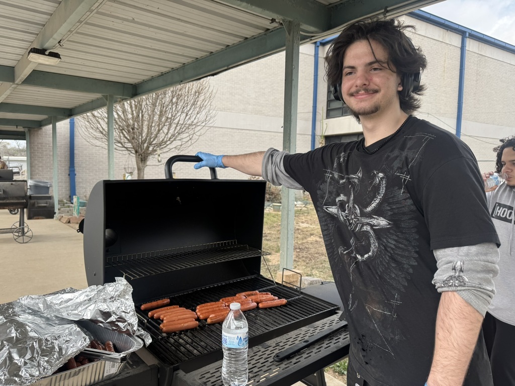 student grilling hotdogs
