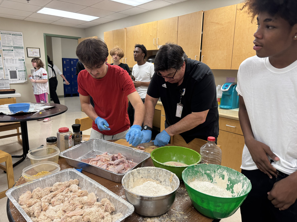 principal preparing food with students