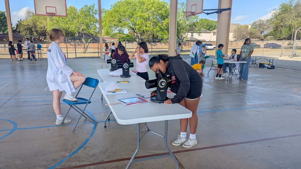 girl looking through microscope.