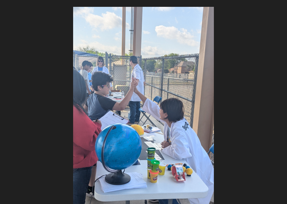 5th grader high fiving a high schooler