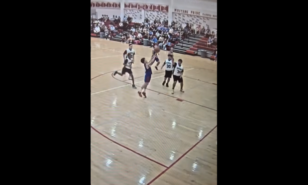 a student shooting the ball at a basketball game