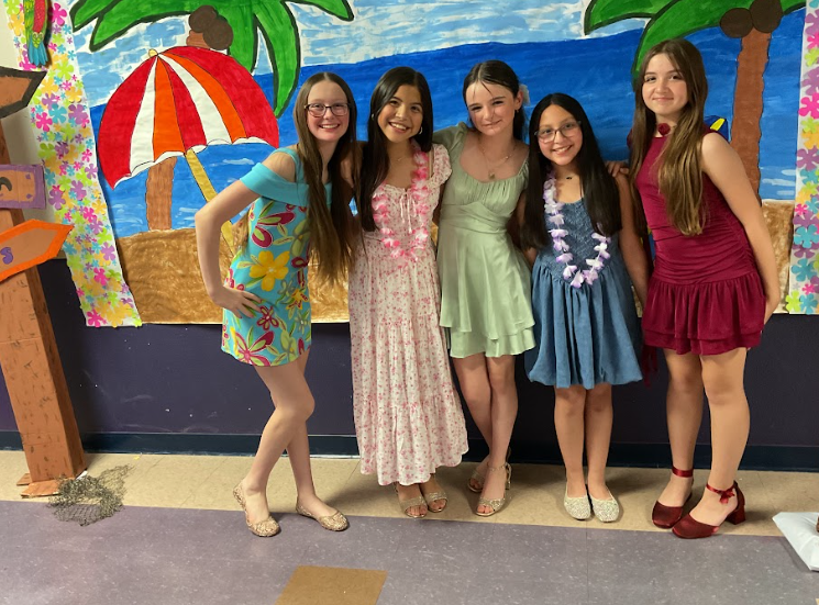 Five girls in dresses posing for a picture