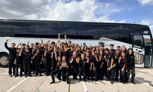 group band photo in front of the charter bus