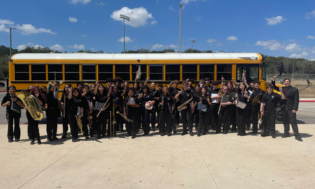 group band photo in front of the school bus
