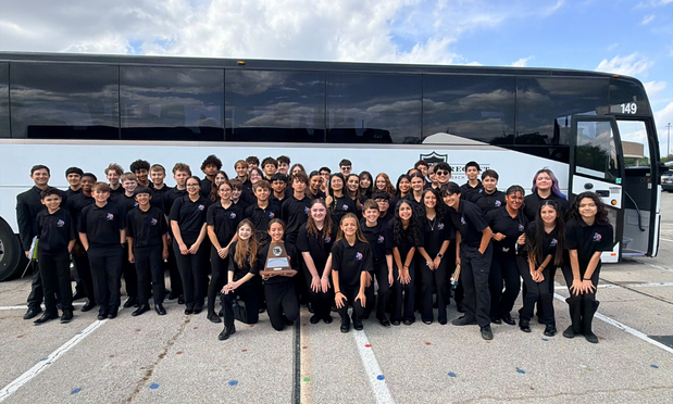 group band photo in front of the charter bus
