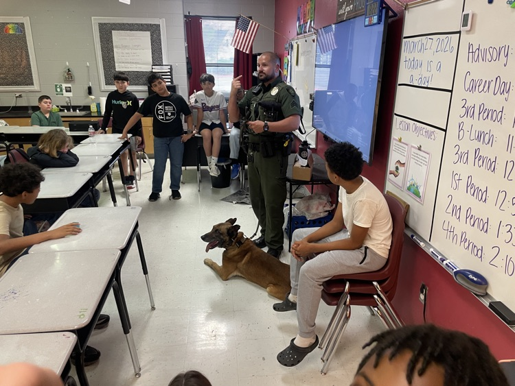 students listening to officer with police talk