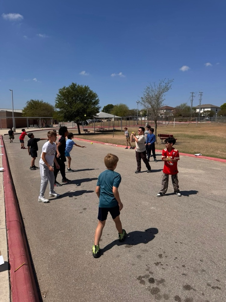 students throwing tennis balls outside to collect data