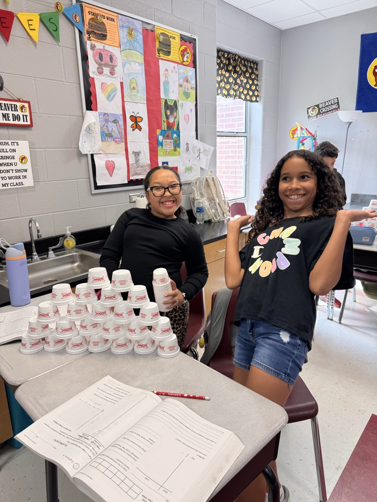 Two girls posing with their Styrofoam cup stack
