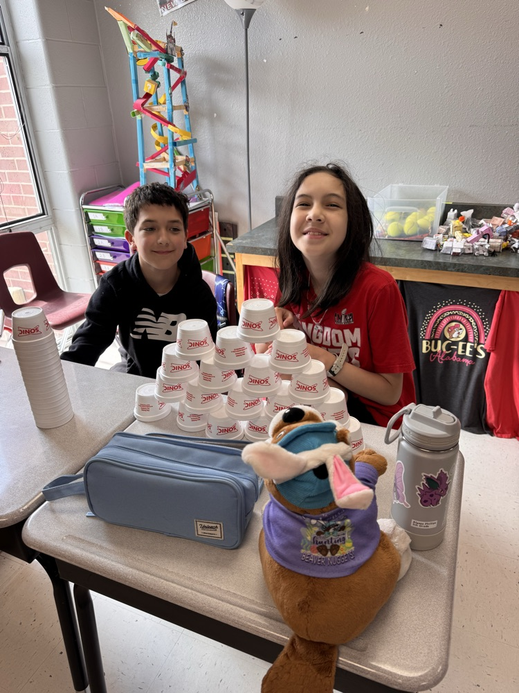 two students posing with their cup stacks