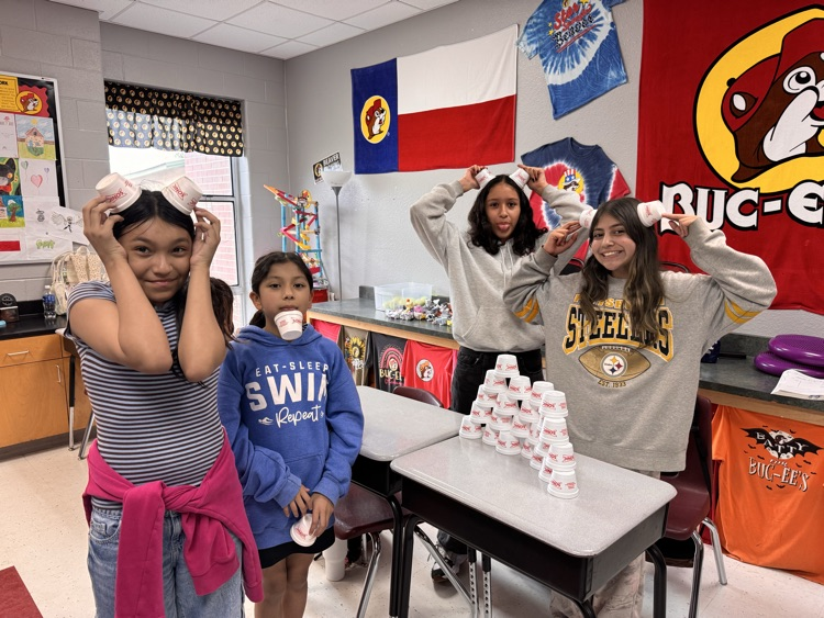 Four girls posing with their cup stack and holding cups on the top of their head like horns