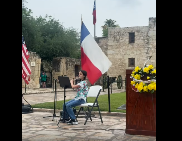 Jewel playing her flute infront of the Alamo
